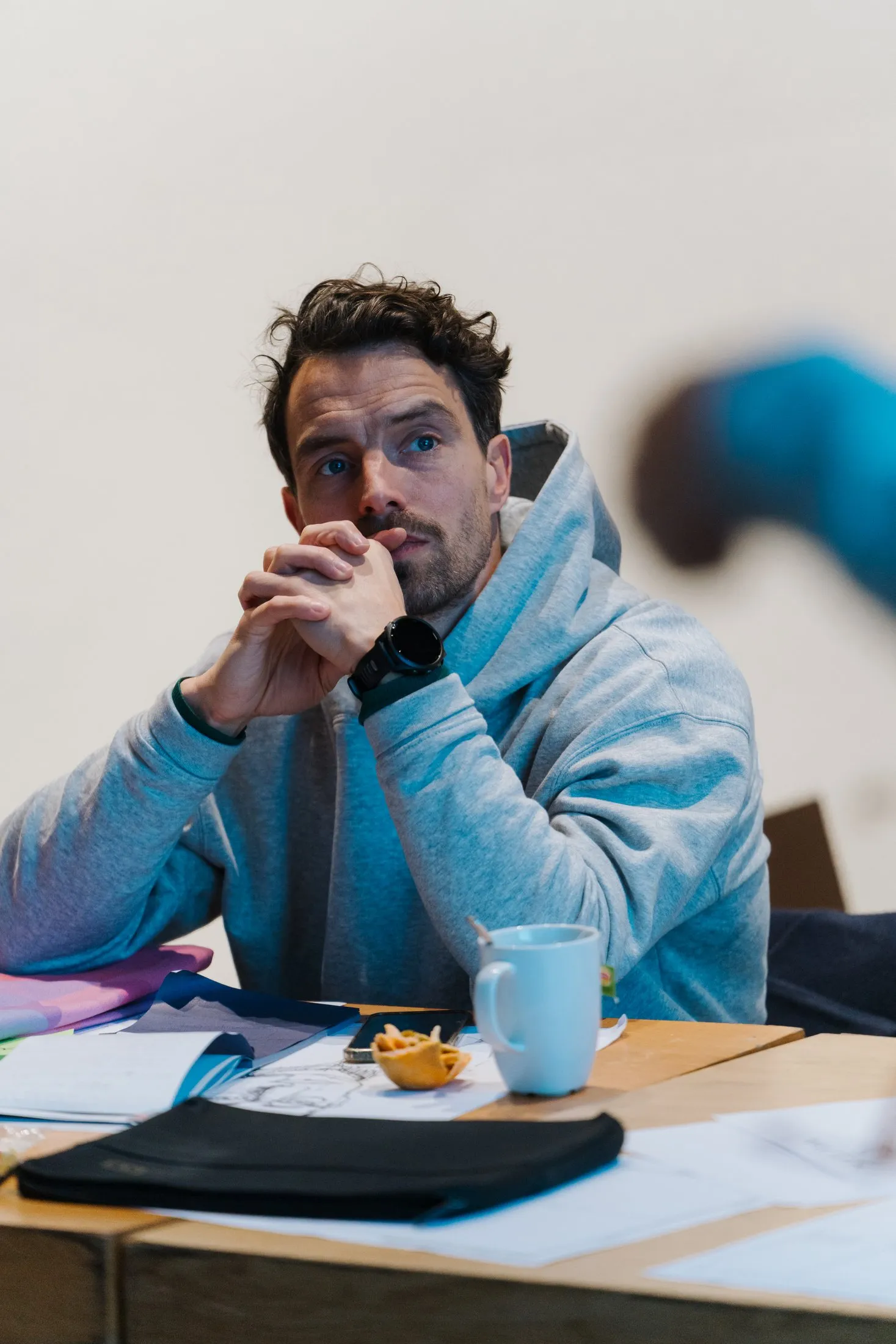 A founder listening at a bootcamp table, hands together