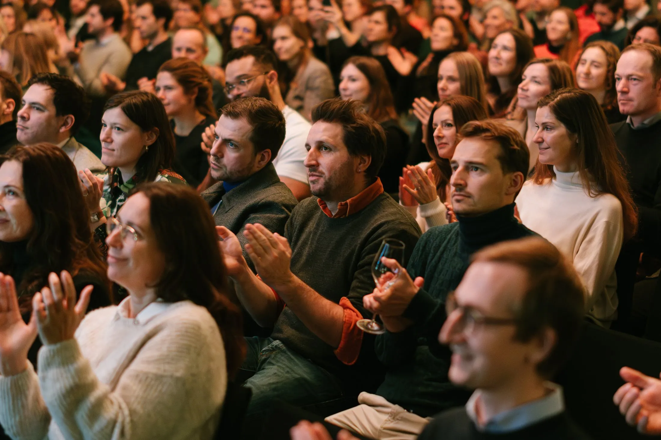 Une salle comble applaudissant à la fin d'un récit