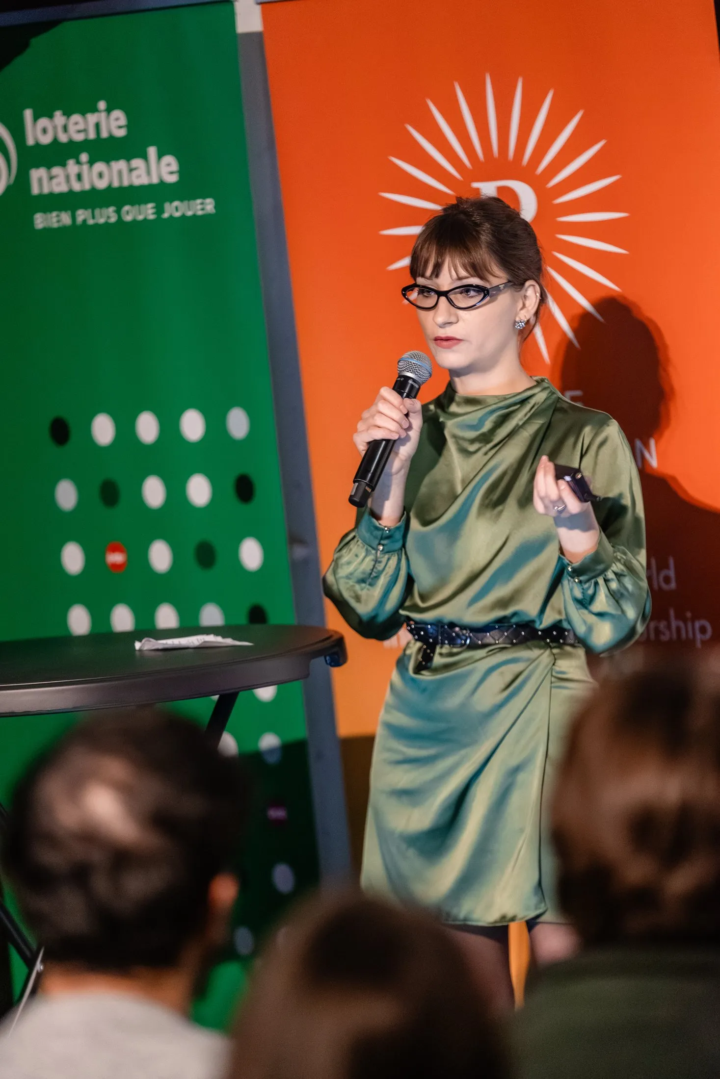 Une intervenante au micro devant le kakémono orange de Pulse Foundation