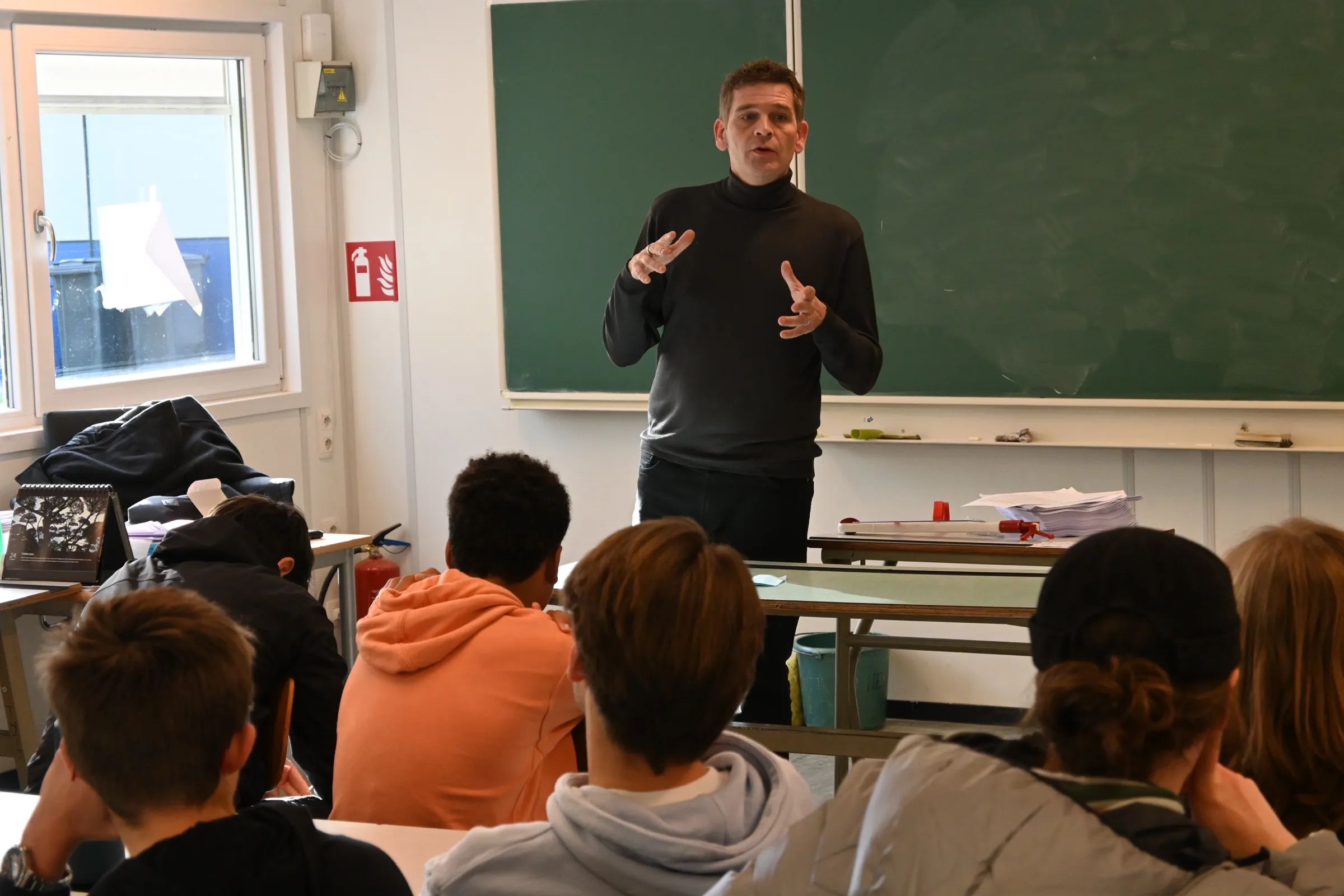 Un enseignant anime une séance devant une classe du secondaire.
