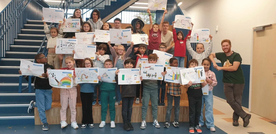 Des enfants brandissent les machines de rêve qu'ils ont inventées pour MyMachine.