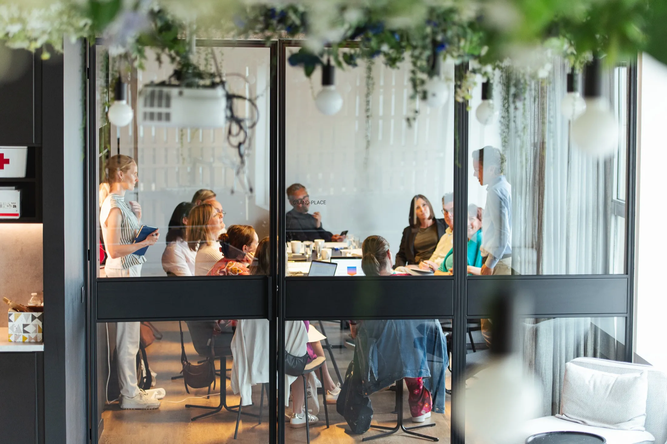 The session seen through glass doors hung with greenery