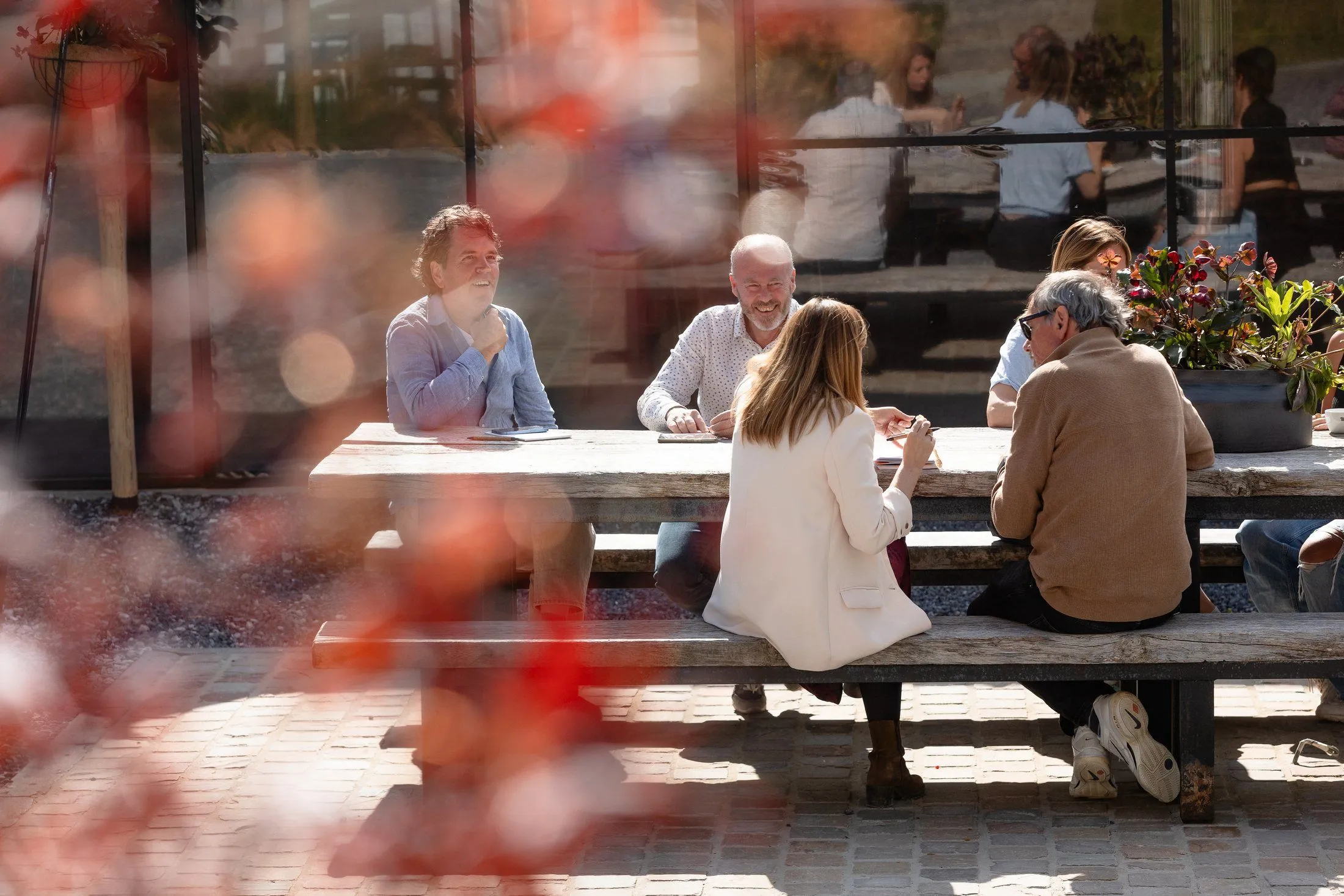 Des partenaires du programme RISE discutant à une longue table sous la lumière d'automne